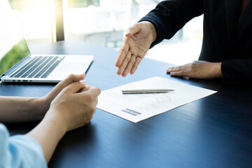 A female finance worker sitting opposite the manager gets a handshake. To express the pleasure that has passed the selection of persons to work in the company, concept of congratulation In recruiting