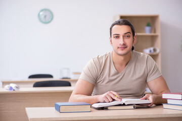 Young male student preparing for exams at library