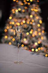 a glass of champagne on the background of a Christmas tree with lights
