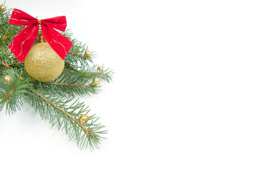 Christmas decoration, shiny yellow ball with a red bow on a Christmas tree branch isolated on a white background