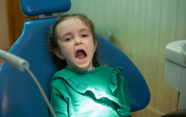 Child at the dentist's appointment. Doctor's appointment. Little girl treats teeth