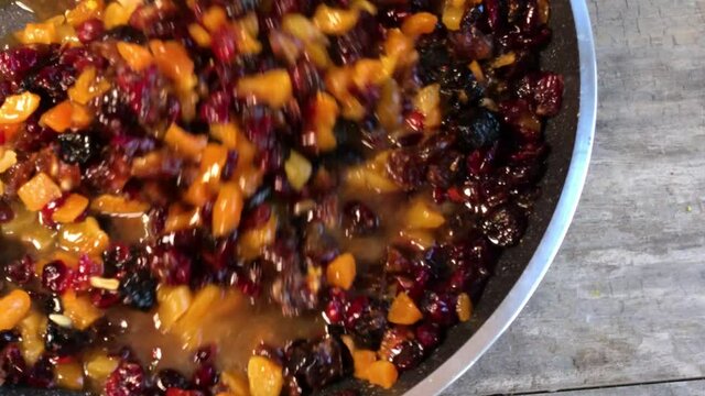 simmering dried fruits and zest of orange and lemons for holiday fruit cake flat lay