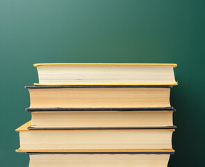 blank green chalk school board and stack of books,