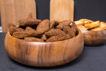 brown croutons in bowl. croutons in a brown bowl on a wooden table. Close-up. Selective focus.