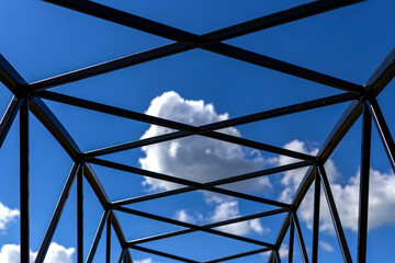 Silhouette of metal frame and blue sky background.