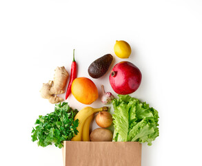 Paper grocery bag full of healthy fruits and vegetables top view isolated on white background