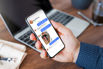 Man exchanging lovely messages with his girlfriend on phone at work