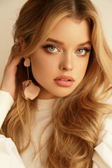 beautiful young woman with blond hair in cozy clothes and accessories