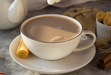 Fototapeta na wymiar A woman's hand puts a lump of sugar in a white mug of tea