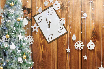 Christmas background with clock, snow fir tree and gift boxes over wood
