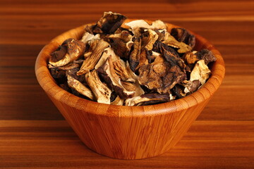 Dried mushrooms in wooden bowl. Boletus badius.