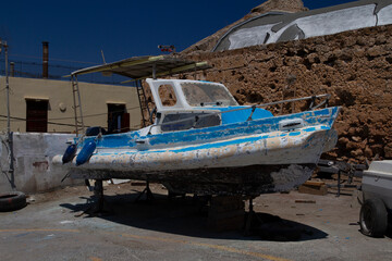 Fototapeta premium construction of an old blue-white broken ship on land during the day