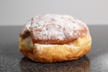 Doughnut without a hole filled with jam with sugar on top