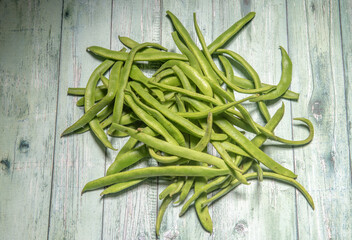 Homegrown green beans on a green wooden background 