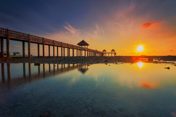 Fototapeta na wymiar A long exposure picture of majestic sunrise with a jetty as a background at Tanjung Balau, Johore