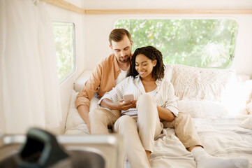 Love couple relax in bed, camping in a trailer