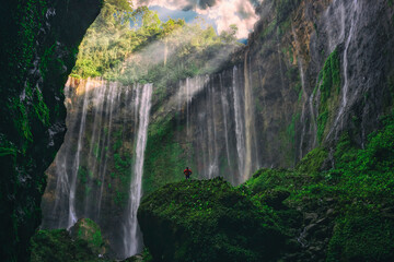 A hiker enjoys the view of beautiful Waterfall