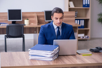 Young male employee unhappy with excessive work