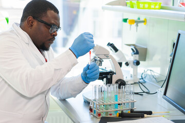 African-american man working in lab. Scientist doctor making medical research. Laboratory tools:...