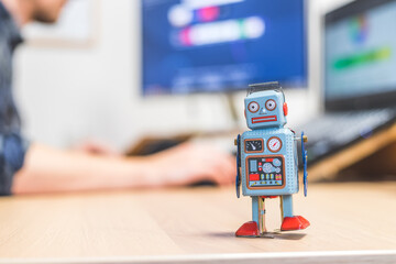 Artificial intelligence concept: Toy robot on office desktop. Metaphor for chatbot, social bot and...