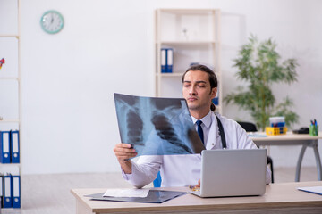 Naklejka premium Young male doctor radiologist working in the clinic