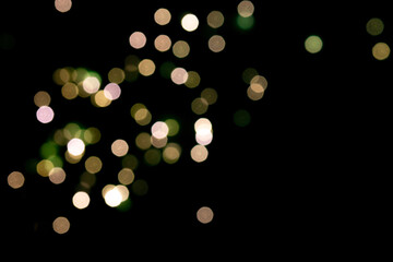 Green and yellow bokeh lights on black background