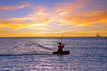 Naklejka premium Kite surfing at Palm Beach on Aruba island in the Caribbean Sea at sunset