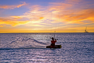 Kite surfing at Palm Beach on Aruba island in the Caribbean Sea at sunset