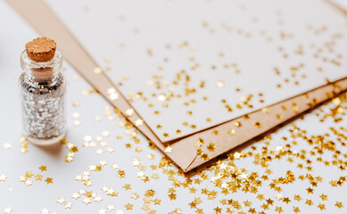 Blank note with envelope, gifts and gold glitter stars on white background