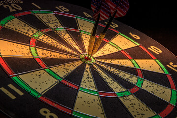 Three Darts with American flags in the center of the target on a black background. Success, luck,...