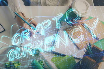 Cryptocurrency hologram, bitcoin, ico theme over hands taking notes background. Concept of...
