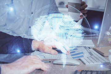 Fototapeta premium Man with computer background with brain theme hologram. Concept of brainstorm. Double exposure.