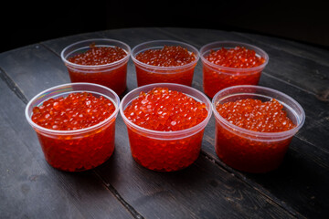 Pink salmon caviar and chum salmon caviar in plastic containers. Seafood, delicacies, healthy nutrition. 