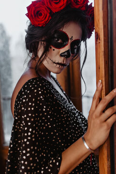 Proud, mysterious Latin model boldly looks into lens. Custom Halloween makeup adds glamor to image of young woman