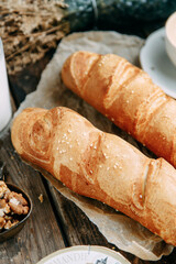 Top view of fresh wholegrain bread with butter on paper. Bread lying on a dark wooden background.