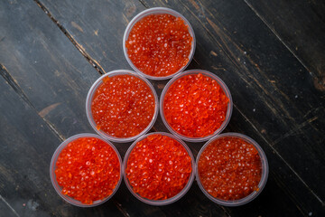 Pink salmon caviar and chum salmon caviar in plastic containers. Seafood, delicacies, healthy nutrition. 