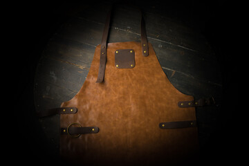 Protective brown leather apron on dark background