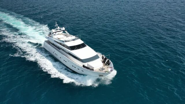 Aerial tracking top down video of luxury yacht cruising in deep blue open ocean sea
