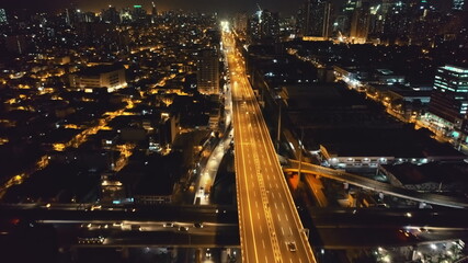 Slow motion night traffic road at twilight cityscape aerial view. Drone flying above urban junction...