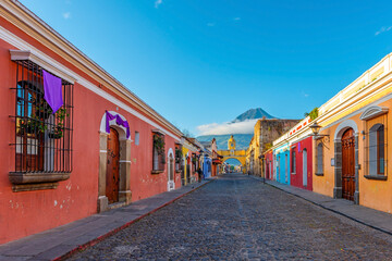 Cityscape of Antigua city at sunrise with the Santa Catalina arch and Agua volcano with copy space, Guatemala.