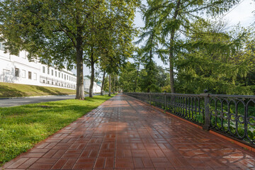 The pavement, paved with red paving slabs, has just been scrubbed with a scrubber.