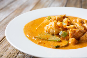 A view of a bowl of red curry with calamari.