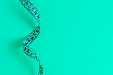 Blue meandering measuring tape on blue background.