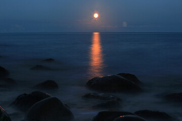 Stones in the water and sea on a moonlit night