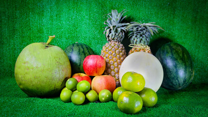 Oranges and lemons, a variety of mixed fruits placed on the green grass, have healthy vitamins.