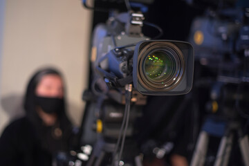 masked cameraman is filming a television show in the studio.