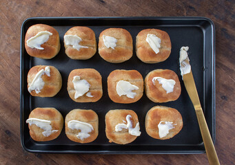 baked dinner rolls topped with butter in pan flat lay
