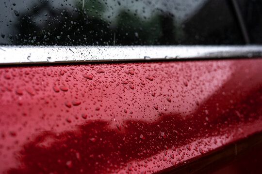 Raindrops Close Up On A Red Car Body Macro Photo.