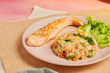 Tasty dinner or lunch, healthy asian food. Grilled Salmon with Japanese fried rice and vegetables. Salmon Chahan Rice on wooden table