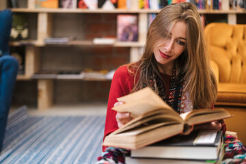 Pretty blonde woman reading a book in a bookstore.